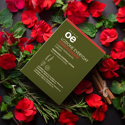 immagine del prodotto della lozione energizzante ambientata su sfondo di fiori rossi